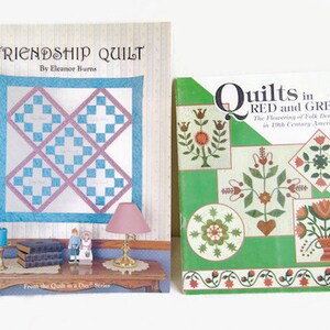 K&ouml;nnte beinhalten: Zwei Quiltb&uuml;cher, eines mit dem Titel "Friendship Quilt" von Eleanor Burns und das andere mit dem Titel "Quilts in Red and Green: The Flowering of Folk Design in 19th Century America".
