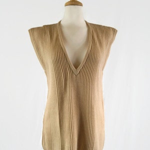 May include: A sleeveless, tan ribbed knit sweater with a deep V-neck.