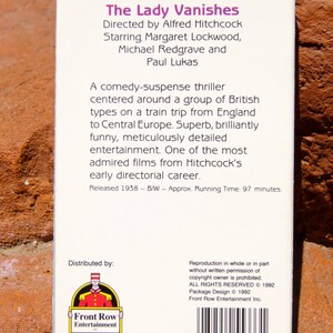 May include: The Lady Vanishes VHS tape case, featuring a black and white image of a clapperboard with arrows. The text on the case reads "The Lady Vanishes", "Directed by Alfred Hitchcock", "Starring Margaret Lockwood, Michael Redgrave and Paul Lukas", "Released 1938 - B/W - Approx. Running Time: 97 minutes."