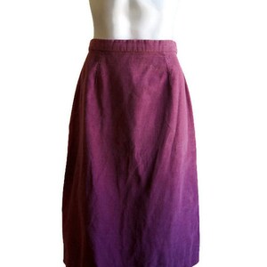 May include: A purple and pink ombre midi skirt made of corduroy.