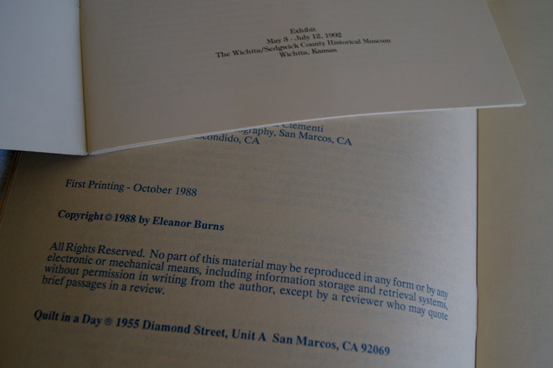K&ouml;nnte beinhalten: Ein Buch mit dem Titel "Quilt in a Day" mit den Copyright-Informationen "Copyright &copy; 1988 by Eleanor Burns" und den Verlagsinformationen "First Printing - October 1988". Das Buch enth&auml;lt auch die Adresse "1955 Diamond Street, Unit A San Marcos, CA 92069".