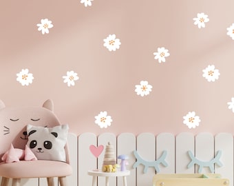 Könnte beinhalten: Ein rosa Kinderstuhl mit Katzenkopf-Design, einem Panda-Kissen und einem Hintergrund aus weißem Lattenzaun. Weiße Gänseblümchen-Aufkleber sind auf einer hellrosa Wand verteilt.