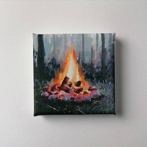 Könnte beinhalten: Ein Gemälde eines Lagerfeuers in einem Wald. Die Flammen sind orange und gelb, und die Holzscheite sind rot und braun. Der Hintergrund ist dunkelgrün.