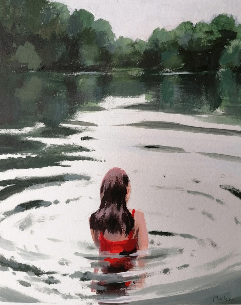 May include: A woman in a red swimsuit stands in a lake, facing away from the viewer. The water is calm and reflects the surrounding trees.