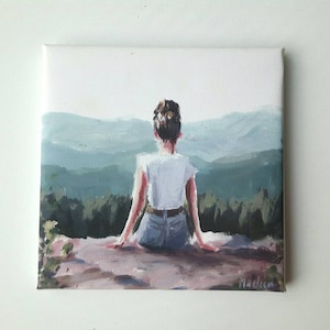 Op de afbeelding: Een schilderij van een persoon die op een rots zit en uitkijkt over een bergketen. De persoon draagt een wit shirt en een blauwe jeans. De bergen zijn geschilderd in tinten groen en blauw.
