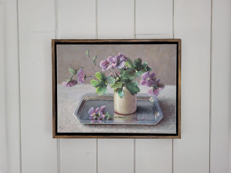 May include: A painting of a bouquet of purple flowers in a white vase on a silver tray. The flowers are arranged in a simple, elegant way, and the painting is done in a realistic style.