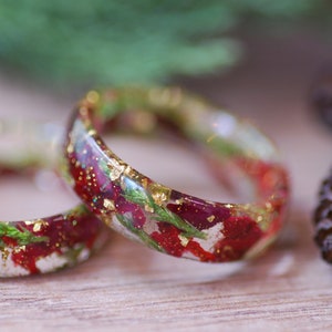 Kerstharsring: rode roos, groene jeneverbes en gouden vlokken vakantiesieraden