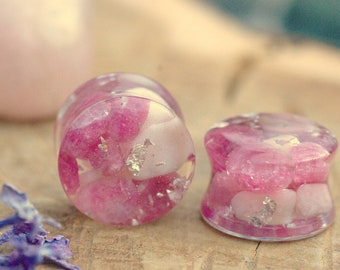 May include: Two pink and white resin ear gauges with embedded silver flakes and pink and white stones.