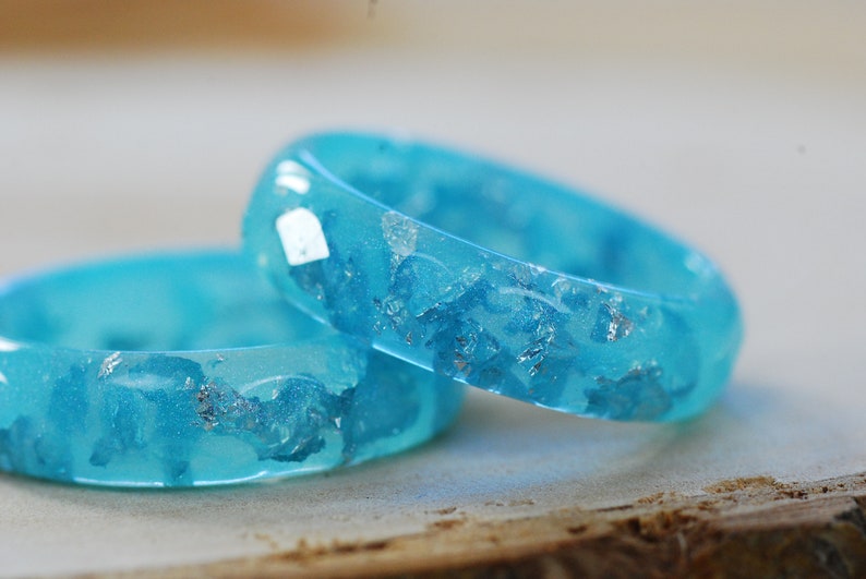 Resin ring faceted and geometric on the outside made of pastel blue color and silver flakes