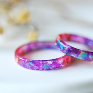 虹色に輝く紫の樹脂リング、ホログラフィックピンクのグリッターバンド、妖精のジュエリー