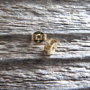 Peut inclure: Deux dos d'oreille en or, l'un portant la marque "14K" au dos.