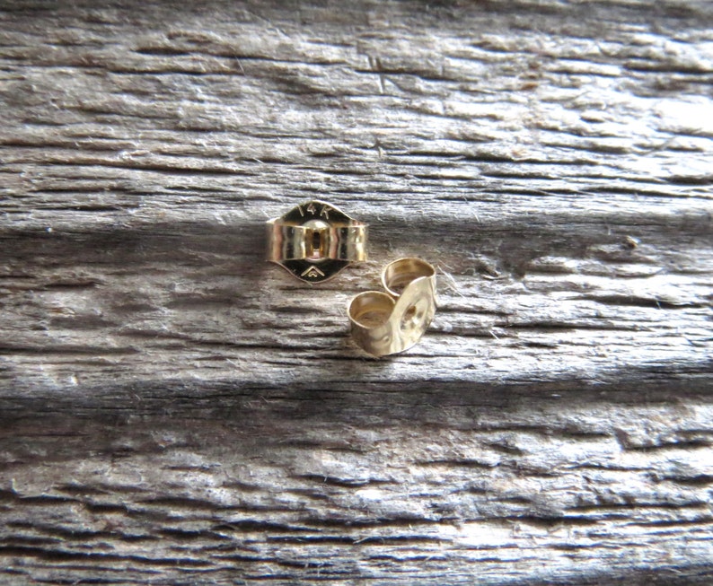 Peut inclure: Deux dos d'oreille en or, l'un portant la marque "14K" au dos.