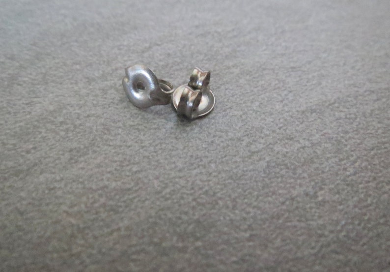 Puede incluir: Respaldos de pendientes de plata, tambi&eacute;n conocidos como respaldos de mariposa, son un tipo com&uacute;n de cierre para pendientes. Estos respaldos est&aacute;n dise&ntilde;ados para asegurar los pendientes al l&oacute;bulo de la oreja.