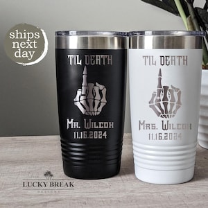 May include: Two stainless steel tumblers with black and white finishes. Each tumbler features a skeleton hand giving the middle finger with the text "Til Death" above it. The tumblers are personalized with the names "Mr. Wilcox" and "Mrs. Wilcox" and the date "11.16.2024".