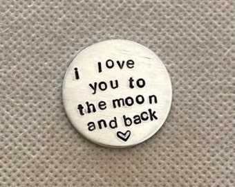 May include: A silver charm with the text "i love you to the moon and back" and a small heart.