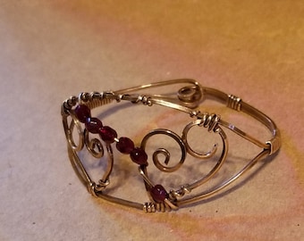 Small cuff bracelet in red bronze wire with natural untreated garnet beads is a comfortable style with a clasp built right into the design.