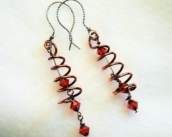 Copper wire coiled around Indian Red Swarovski crystals create an abstract Christmas Tree earring. Hand made earwires.  2 inch drop