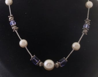 Creamy white pearls and tanzenite crystal cubes  necklace is strung on knotted silk cord. 18 inches long