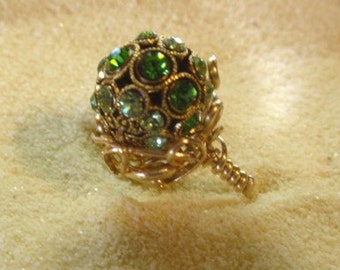 Grand anneau... Des cristaux vert émeraude et péridot de 12 mm cloutent une perle montée dans une enveloppe en filigrane remplie d’or 14 carats.  6 1/2