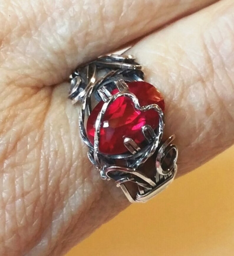 Beautiful Lab created ruby, 12x8mm, is wrapped in sterling silver with antique patina. Prong setting has heart motif in silver. Size 9 1/2 image 1