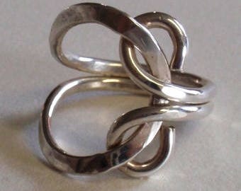 Hand forged scroll designed ring in Fine Silver.  Open on one side and the double band wraps to form the scroll on the other side.  Unique.