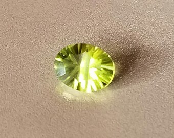 Quantum cut oval Manchurian peridot, 2 carats, 9x7x5mm.  clean stone, deep color saturation.