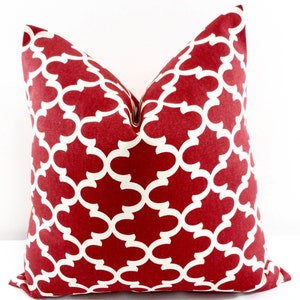 May include: Red and white patterned throw pillow with a geometric design. The pillow is made of a soft, durable fabric and is perfect for adding a touch of style to any room.