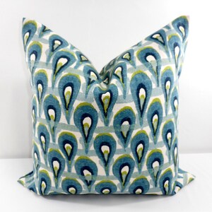 Pu&ograve; includere: Cuscino quadrato decorativo con un motivo a goccia turchese, blu navy e verde su sfondo bianco. Il cuscino ha un aspetto morbido e strutturato. Il design &egrave; ripetuto su tutta la superficie del cuscino.