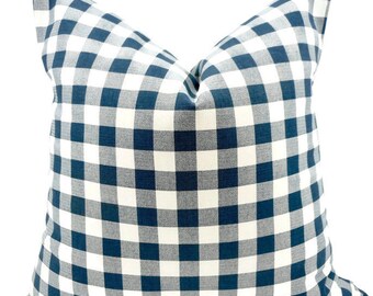 May include: A blue and white gingham pillow cover. The pillow cover is made of a soft, woven fabric and features a classic checkered pattern.
