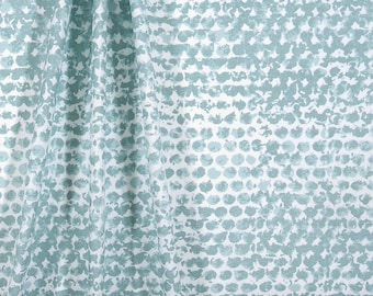 May include: A white fabric with a teal blue pattern of small, irregular circles. The fabric has a subtle texture.