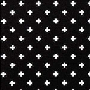 May include: Black fabric with a repeating pattern of white plus signs. The plus signs are evenly spaced across the fabric. The image includes a ruler along the bottom edge, showing measurements in inches.