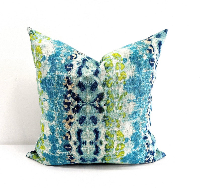 Pu&ograve; includere: Un cuscino quadrato decorativo con un vivace motivo astratto. Il cuscino presenta un mix di tonalit&agrave; blu, verde acqua e verde lime, creando un design strutturato simile a un acquerello. Il cuscino &egrave; di forma quadrata, perfetto per aggiungere colore.
