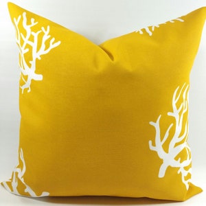 May include: A yellow throw pillow with a white coral reef design.