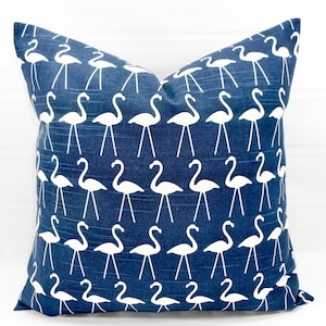 May include: Blue throw pillow with a white flamingo pattern.