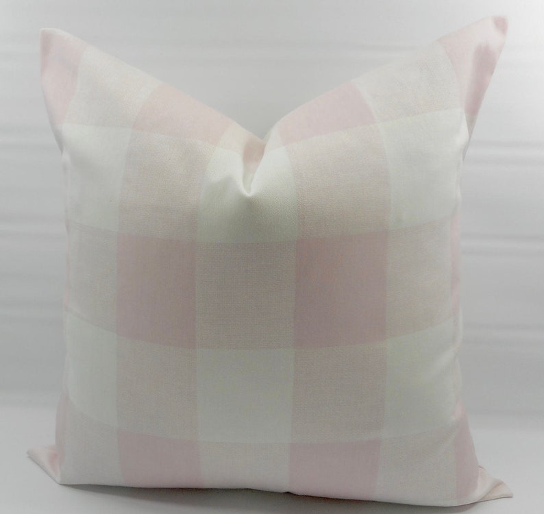 May include: A pink and white gingham pillow cover. The pillow cover is made of a soft, woven fabric and has a subtle sheen.