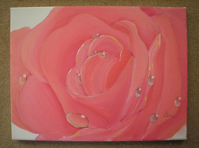 May include: Close-up of a pink rose painting with water droplets. The petals are a soft pink with yellow highlights. The painting is on a white canvas.