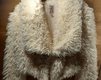 Petite veste shaggy ivoire en fausse fourrure de petite taille, doublée d'un bouton sur le devant, doux comme du beurre