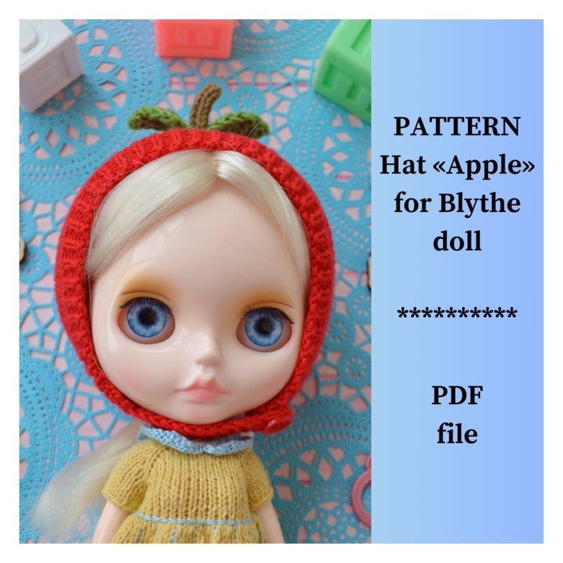 May include: A red knitted hat shaped like an apple with green leaves, worn by a doll with blonde hair and blue eyes. The hat has a red button on the side. The doll is wearing a yellow knitted dress. The image includes the text "PATTERN Hat <<Apple>> for Blythe doll ********** PDF file".
