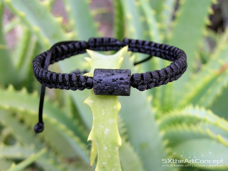 Pode incluir: Pulseira de cord&atilde;o preto com uma conta de rocha vulc&acirc;nica preta. A pulseira &eacute; ajust&aacute;vel com um n&oacute; deslizante.