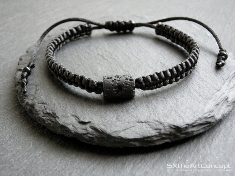 Pode incluir: Pulseira de cord&atilde;o tran&ccedil;ado preto com uma conta de lava preta. A pulseira &eacute; amarrada com um n&oacute; e tem um cord&atilde;o longo para ajustar o ajuste.