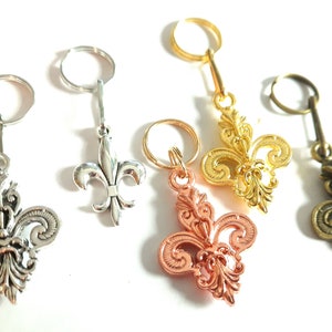 Peut inclure: Quatre porte-clés ornés de motifs de fleurs de lys en argent, or, cuivre et bronze.