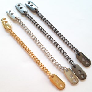 May include: Three chain links with oval-shaped clasps. The chains are gold, silver, and black.