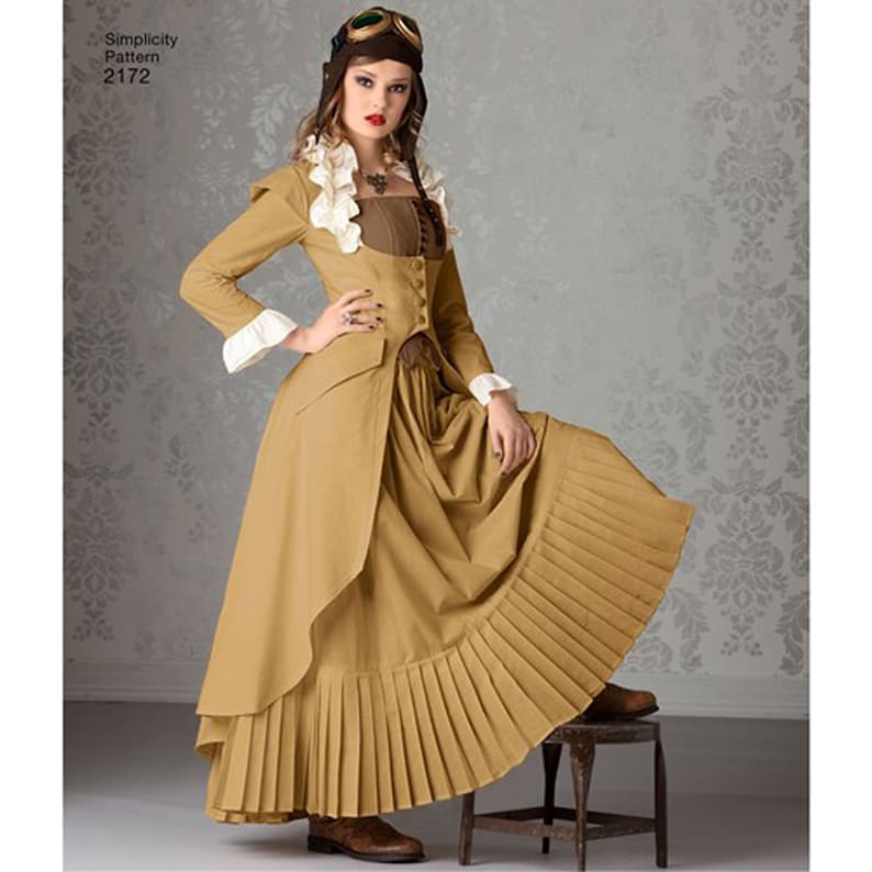 May include: A tan steampunk-style costume with a long skirt, jacket, and ruffled collar. The jacket has white cuffs and a brown bodice. The costume is from Simplicity Pattern 2172. The model is wearing goggles and brown boots.