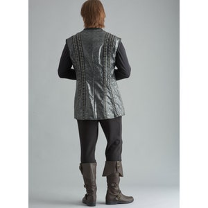 May include: A costume ensemble featuring a textured, silver-grey vest with vertical beaded accents, worn over a black long-sleeved shirt. The outfit includes black trousers and brown leather boots with buckles. The overall look is reminiscent of historical or fantasy attire.