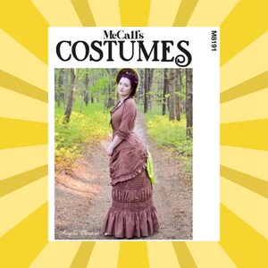 May include: McCall's Costumes pattern M8191. The image shows a woman wearing a brown Victorian era dress. The dress has a ruffled skirt and sleeves. The woman is standing on a path in a forest.