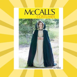 May include: McCall's Costumes pattern featuring a woman in a dark green velvet cloak with a cream-colored dress. The cloak has a hood with white trim. The pattern is labeled M7886.