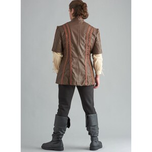 May include: A brown faux leather short-sleeved jacket with decorative stitching, paired with black trousers and grey boots. The jacket has a high collar and is worn over a cream-coloured shirt. The outfit is reminiscent of historical or fantasy attire.
