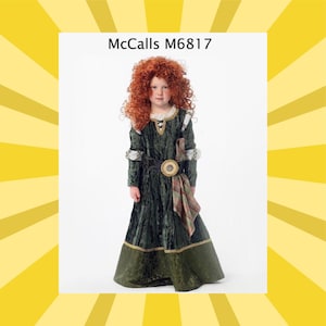 May include: A child wearing a green velvet dress with gold trim, a brown belt with a circular buckle, and a plaid sash. The child has curly red hair and is wearing a costume. The text "McCalls M6817" is at the top.