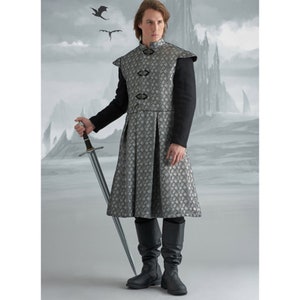 May include: A person in a medieval costume, featuring a silver and grey patterned tunic, black sleeves, and black boots. They are holding a sword. The background shows a castle and dragons.