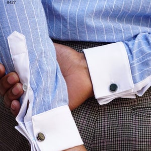 May include: Close-up of a blue and white striped shirt sleeve with a white cuff and a dark gray cufflink. The shirt is part of a Simplicity Pattern 8427.